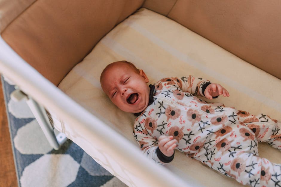 Bebé agotado llorando en su cuna