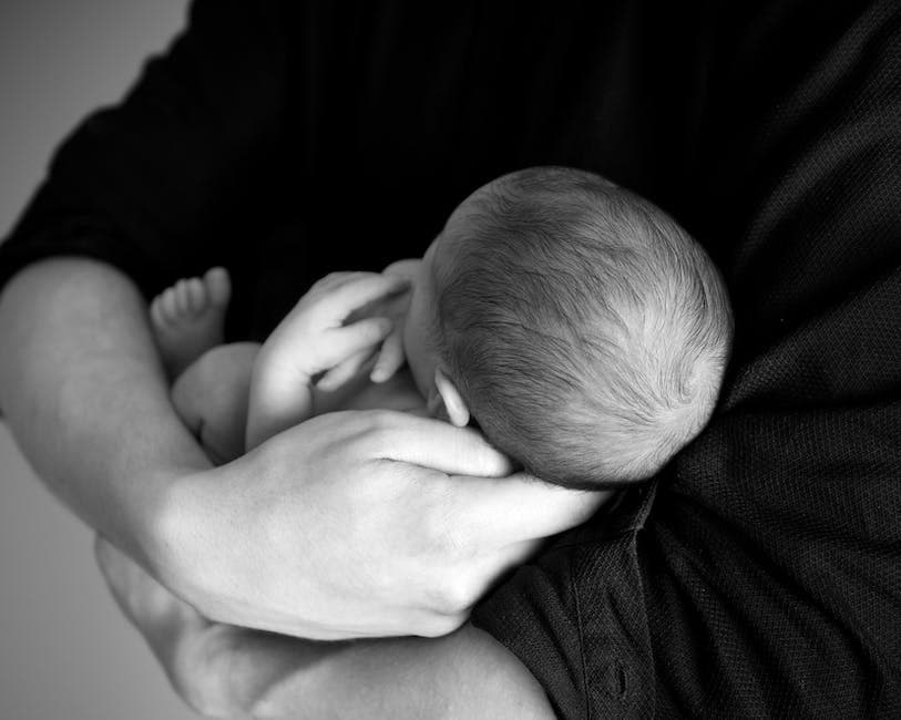 Padre cansado sosteniendo a un bebé llorando