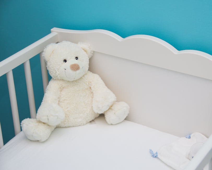 Bebé durmiendo en cuna con juguete de peluche