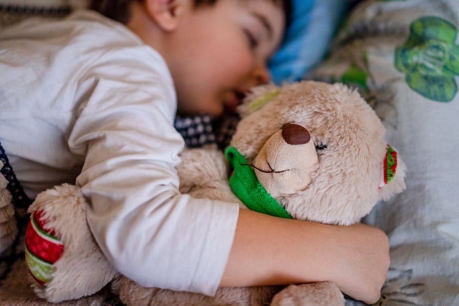Niño durmiendo con un osito de peluche