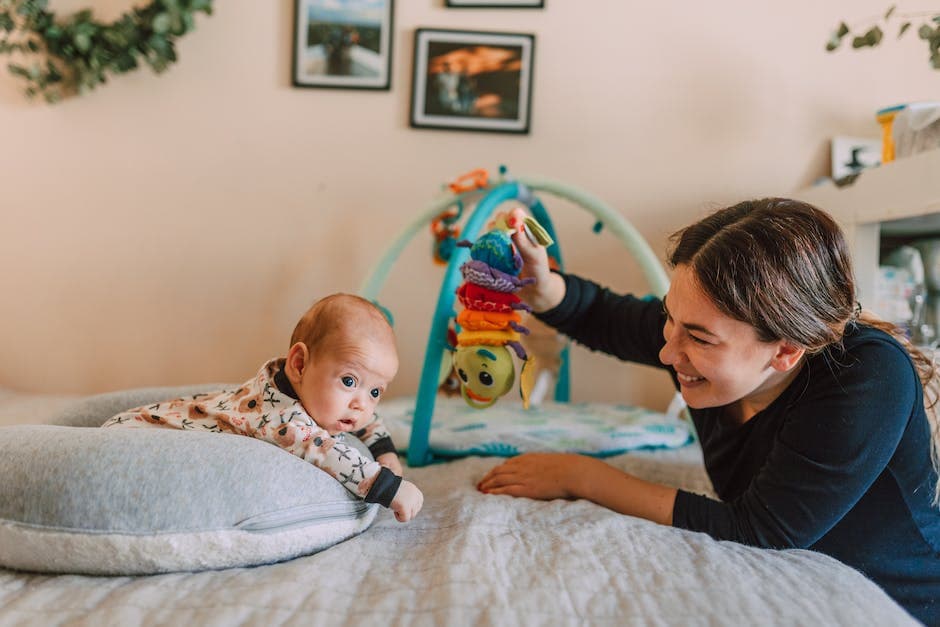 Madre sosteniendo a su bebé mientras está acostado en la cama