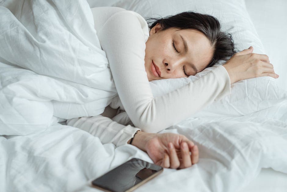 Bebé durmiendo en una cuna segura con ropa de cama adecuada y habitación fresca y oscura