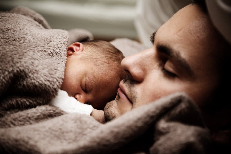 Padre durmiendo mientras el bebé está en su cuna