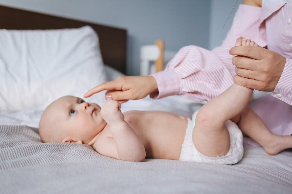 Madre cambia el pañal de su bebé antes de dormir