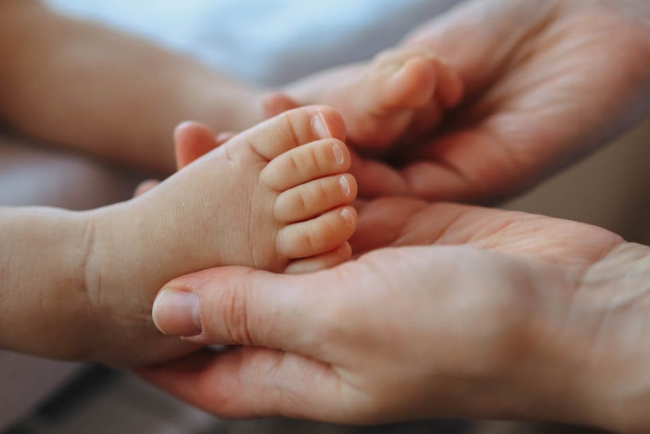 Madre dando un masaje en los pies de su bebé para ayudarlo a dormir