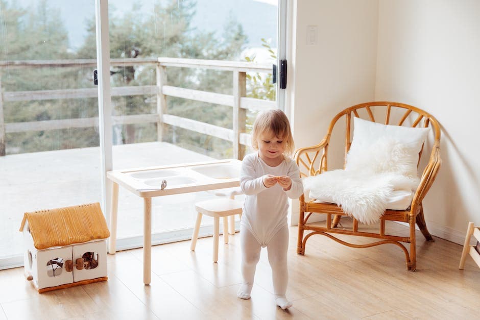 Imagen de una habitación con una cuna, una silla cómoda para lactancia, y un cambiador con pañales y otros suministros para bebés.