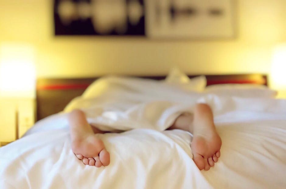 Persona durmiendo rodeada de burbujas de pensamiento y símbolos