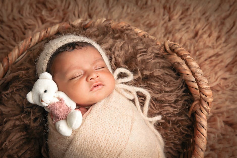 Bebé durmiendo en la cuna con un oso de peluche