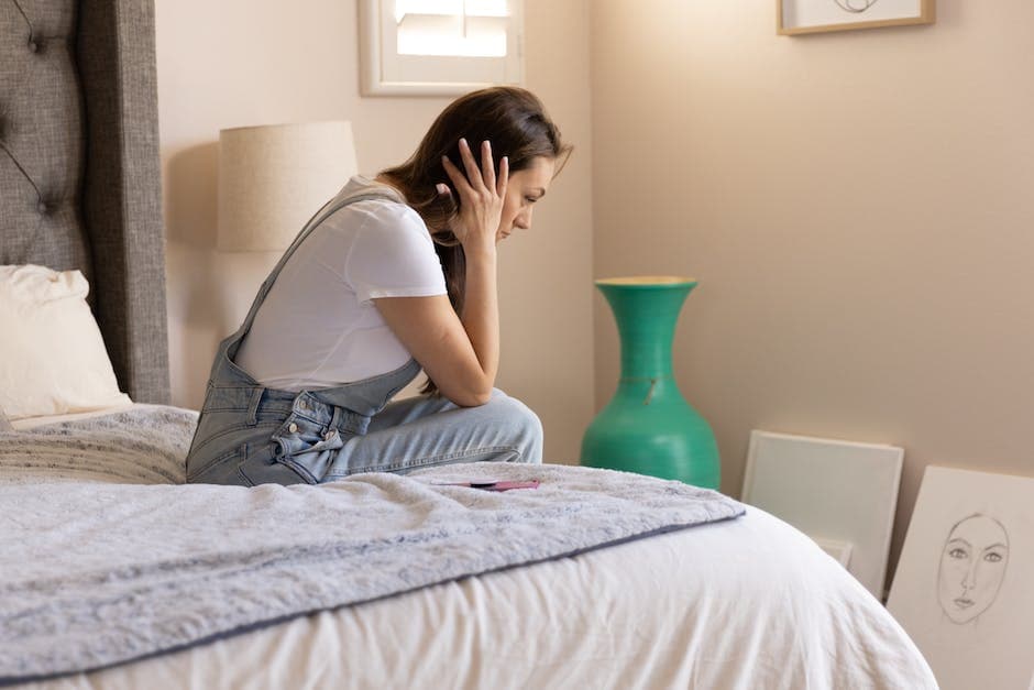 Mujer preocupada sentada en una cama